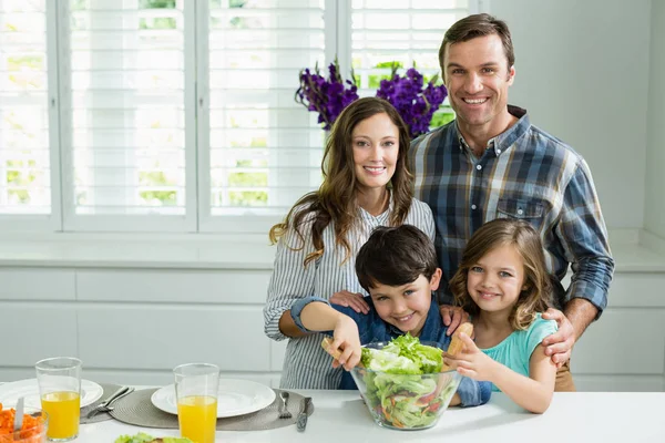 Família preparando tigela de salada na cozinha — Fotografia de Stock
