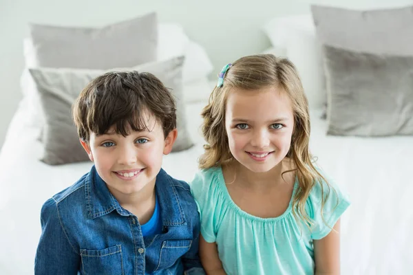 Siblings sitting on sofa in living room — Stock Photo, Image