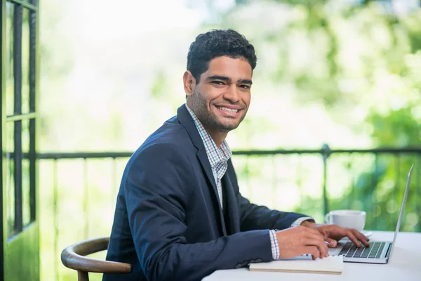 Gelukkig zakenman met laptop in een restaurant — Stockfoto