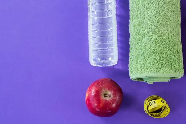 Water bottle, towel, apple and measuring tape — Stock Photo, Image