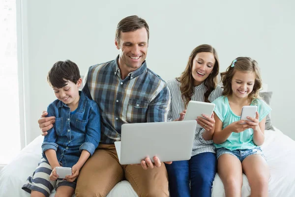 Familie met behulp van laptop, tablet en telefoon — Stockfoto