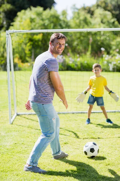 Far och son spelar fotboll — Stockfoto
