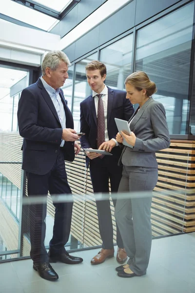 Mensen uit het bedrijfsleven bespreken over elektronische apparaten — Stockfoto