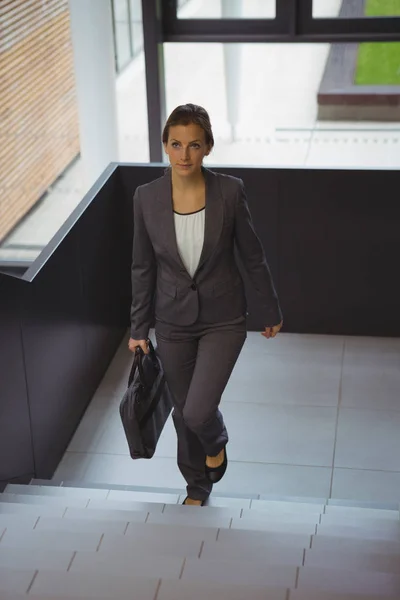 Zakenvrouw met werkmap traplopen — Stockfoto