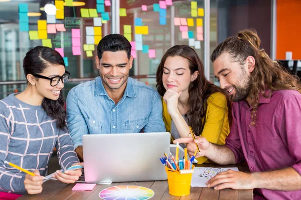 Grafica sorridente che discute sopra computer portatile in riunione — Foto Stock