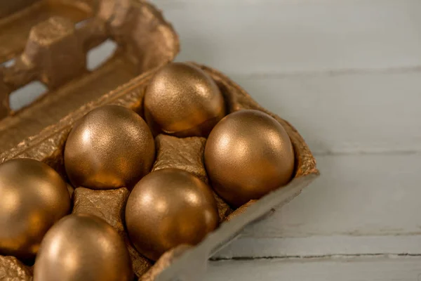 Huevos de Pascua dorados en el cartón —  Fotos de Stock