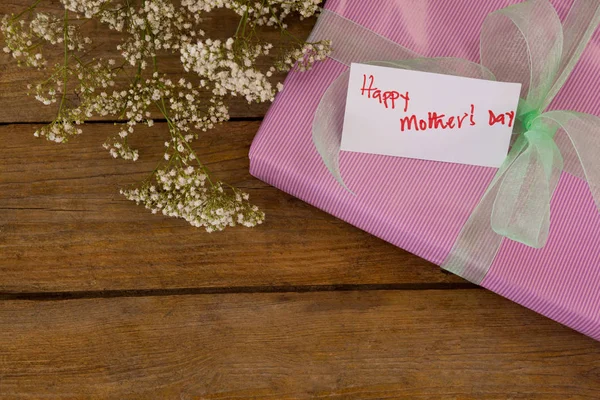 Glückliche Muttertagskarte auf Geschenkbox mit Blumen — Stockfoto