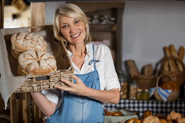 Personnel féminin tenant panier d'aliments sucrés dans la section boulangerie — Photo