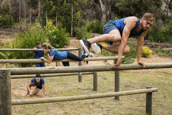 Les gens sautent par-dessus les obstacles pendant le parcours d'obstacles — Photo