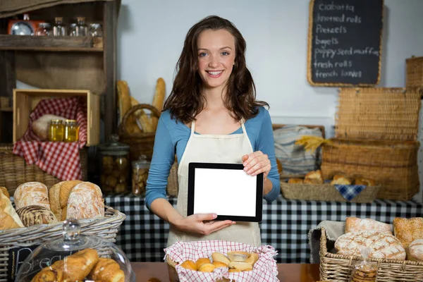 Porträtt av leende personal visar digitala tablett på bageri counter — Stockfoto