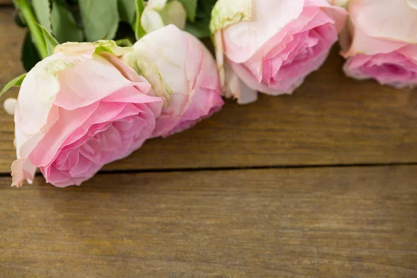 Rosas cor-de-rosa dispostas em prancha de madeira — Fotografia de Stock