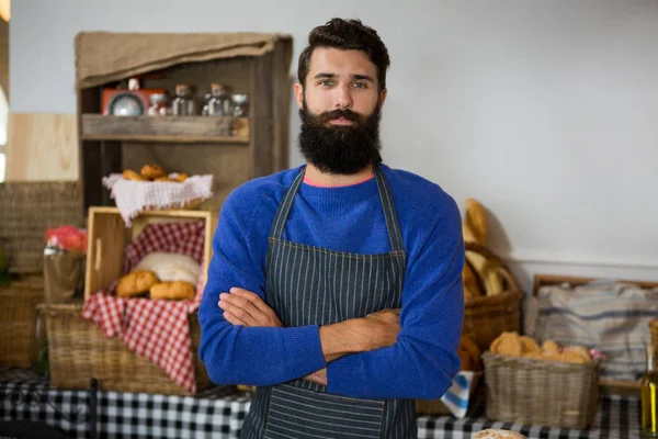 Retrato del bastón masculino de pie con los brazos cruzados en el mostrador — Foto de Stock