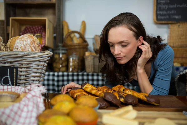 Femme sentant le pain au comptoir de boulangerie — Photo