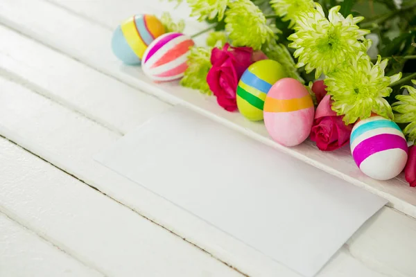 Ovos de Páscoa, cacho de flores e envelope — Fotografia de Stock