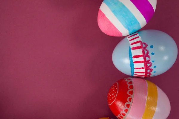 Vários ovos de Páscoa dispostos em fundo rosa — Fotografia de Stock