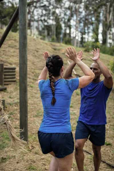 Pareja dando cinco alto uno al otro durante la carrera de obstáculos —  Fotos de Stock