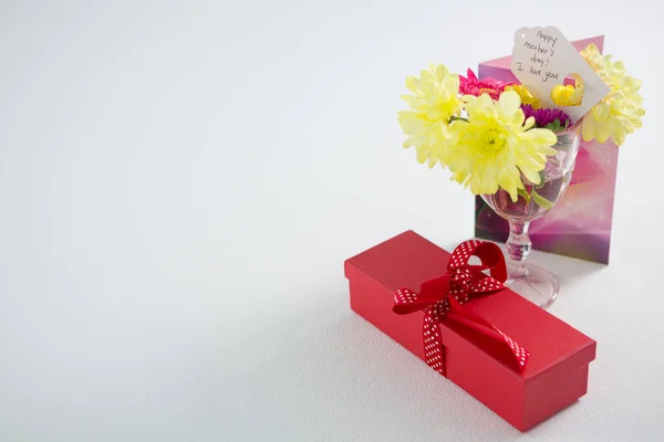 Presentförpackning och blommor i glas med glad mödrar dag tagg — Stockfoto