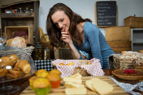 Donna eccitata che acquista cibo dolce al bancone del panificio — Foto Stock