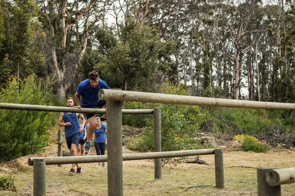 Les gens sautent par-dessus les obstacles pendant le parcours d'obstacles — Photo