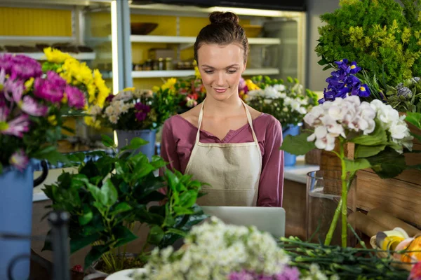 Florist using laptop in flower shop — Stock Photo, Image