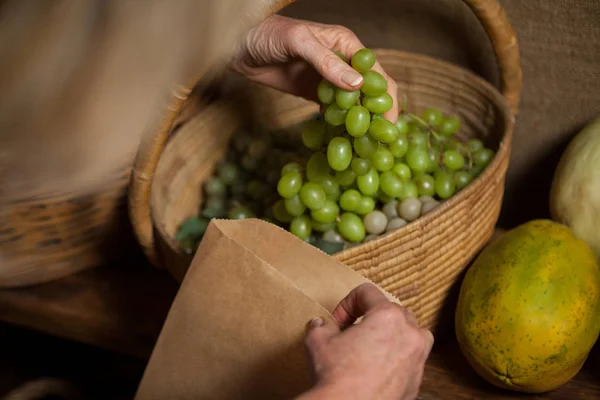 Pessoal que embala uvas em saco de papel — Fotografia de Stock