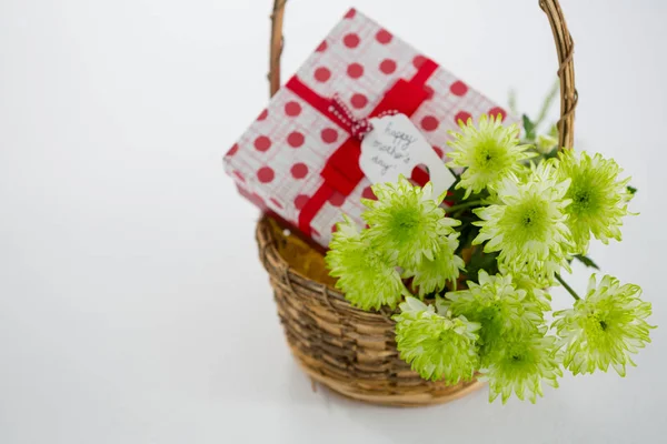 Geschenkbox und gelber Blumenstrauß im Weidenkorb mit glücklichem Muttertagsanhänger — Stockfoto