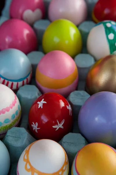 Цветные пасхальные яйца в коробке с яйцами — стоковое фото