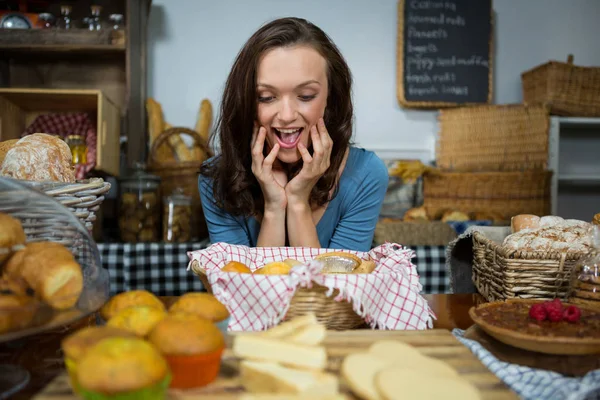 Donna eccitata che acquista cibo dolce al bancone del panificio — Foto Stock