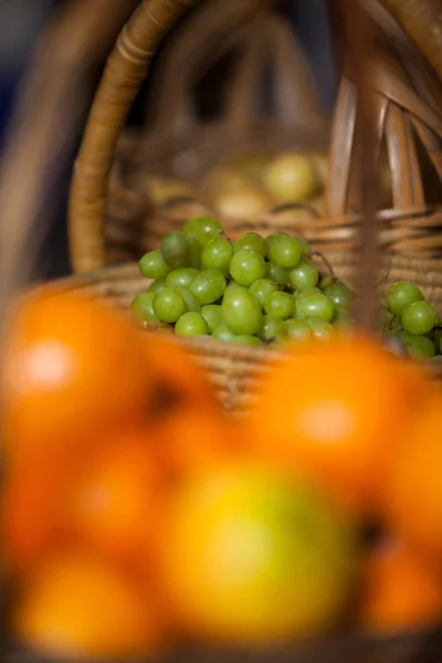 Juicy grapes in wicker basket at organic section — Stock Photo, Image