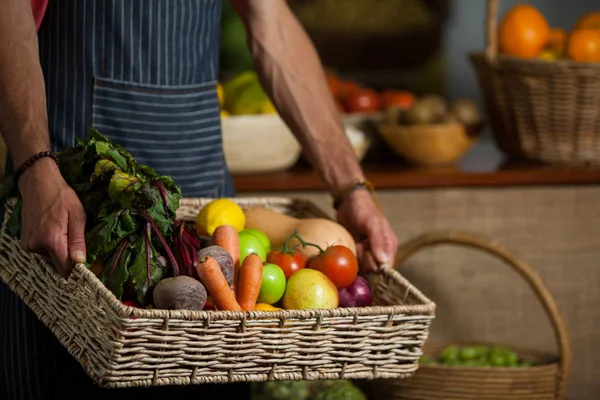 A férfi alkalmazottak gazdaság friss zöldség kosárban szerves szakasz középső rész — Stock Fotó