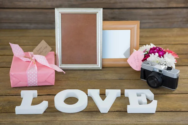 Caja de regalo, marco de fotos, cámara vintage y florero — Foto de Stock