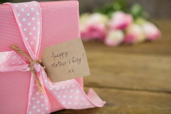 Caja de regalo con etiqueta feliz día de la madre en superficie de madera —  Fotos de Stock