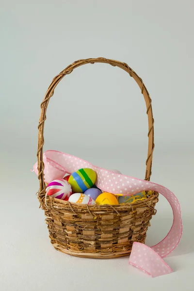 Various Easter eggs in wicker basket — Stock Photo, Image