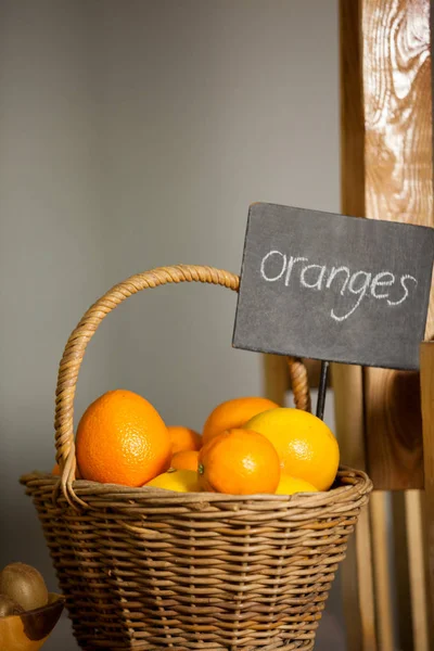 多汁橙在柳条篮子在有机部分 — 图库照片