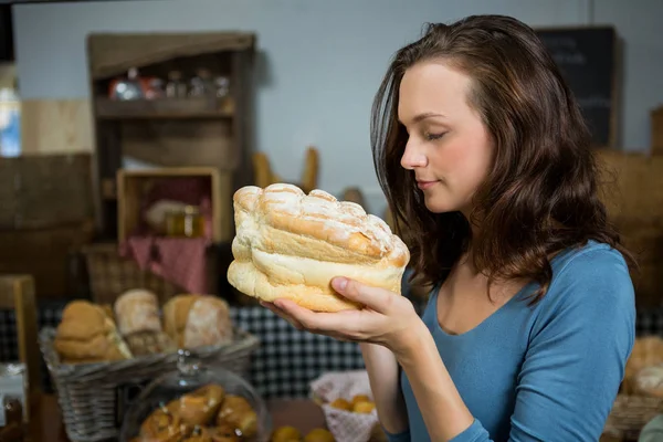 Mulher cheirando pão no balcão da padaria — Fotografia de Stock