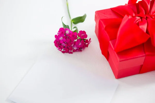 Geschenkbox und rosa Blume mit leerem Papier — Stockfoto