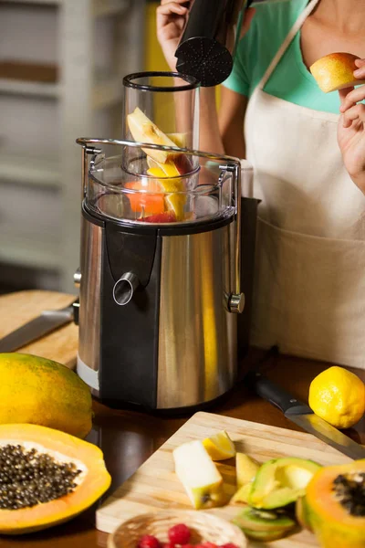 Shop assistant preparing juice at health grocery shop — Stock Photo, Image