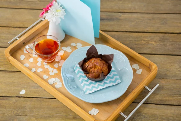 Cupcake, chá, vaso de flores e cartão na bandeja — Fotografia de Stock