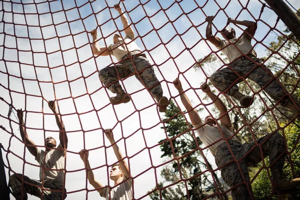 Militaire soldaten klimtouw tijdens hindernissenparcours — Stockfoto