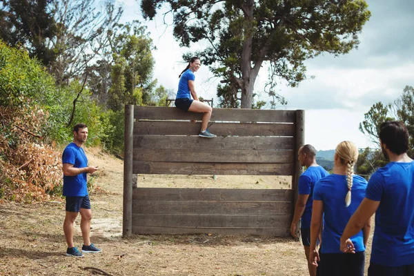 Fit femme assise sur un mur en bois pendant le parcours d'obstacles — Photo