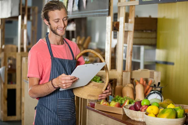 Mannlig personale som ser på skriveplate i organisk seksjon – stockfoto