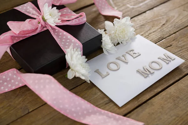 Caja de regalo con texto de mamá amor en tablón de madera — Foto de Stock