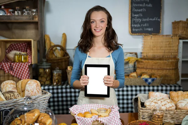 Porträtt av leende personal visar digitala tablett på bageri counter — Stockfoto