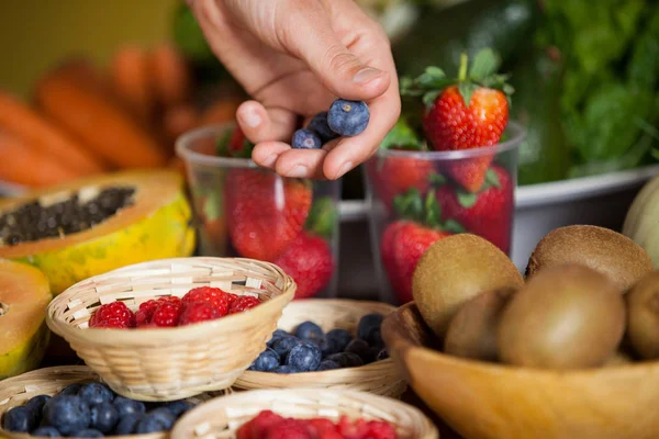 Hand of male staff holding blueberries — Stock Photo, Image