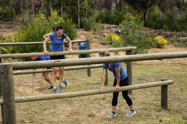 Les gens sautent par-dessus les obstacles pendant le parcours d'obstacles — Photo