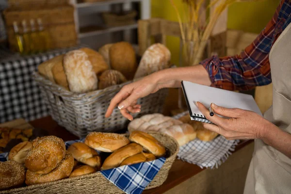 Mitarbeiterinnen halten Bestandsaufnahme an der Brottheke — Stockfoto