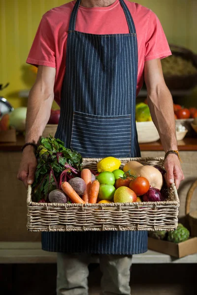 Secção intermédia do pessoal masculino que detém legumes frescos em cesto na secção orgânica — Fotografia de Stock