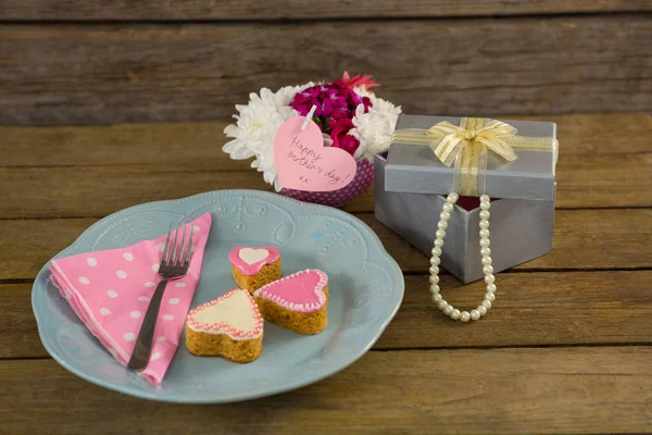 Open geschenkdoos met bloem vaas en hart vorm cookies — Stockfoto