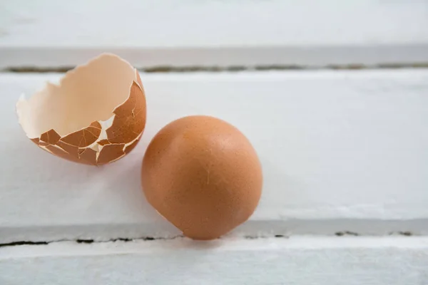 Ovo de Páscoa marrom quebrado na superfície de madeira — Fotografia de Stock