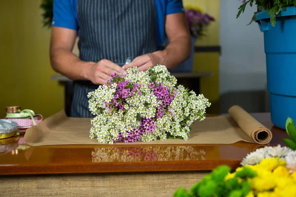 Florista masculino preparando um buquê de flores — Fotografia de Stock